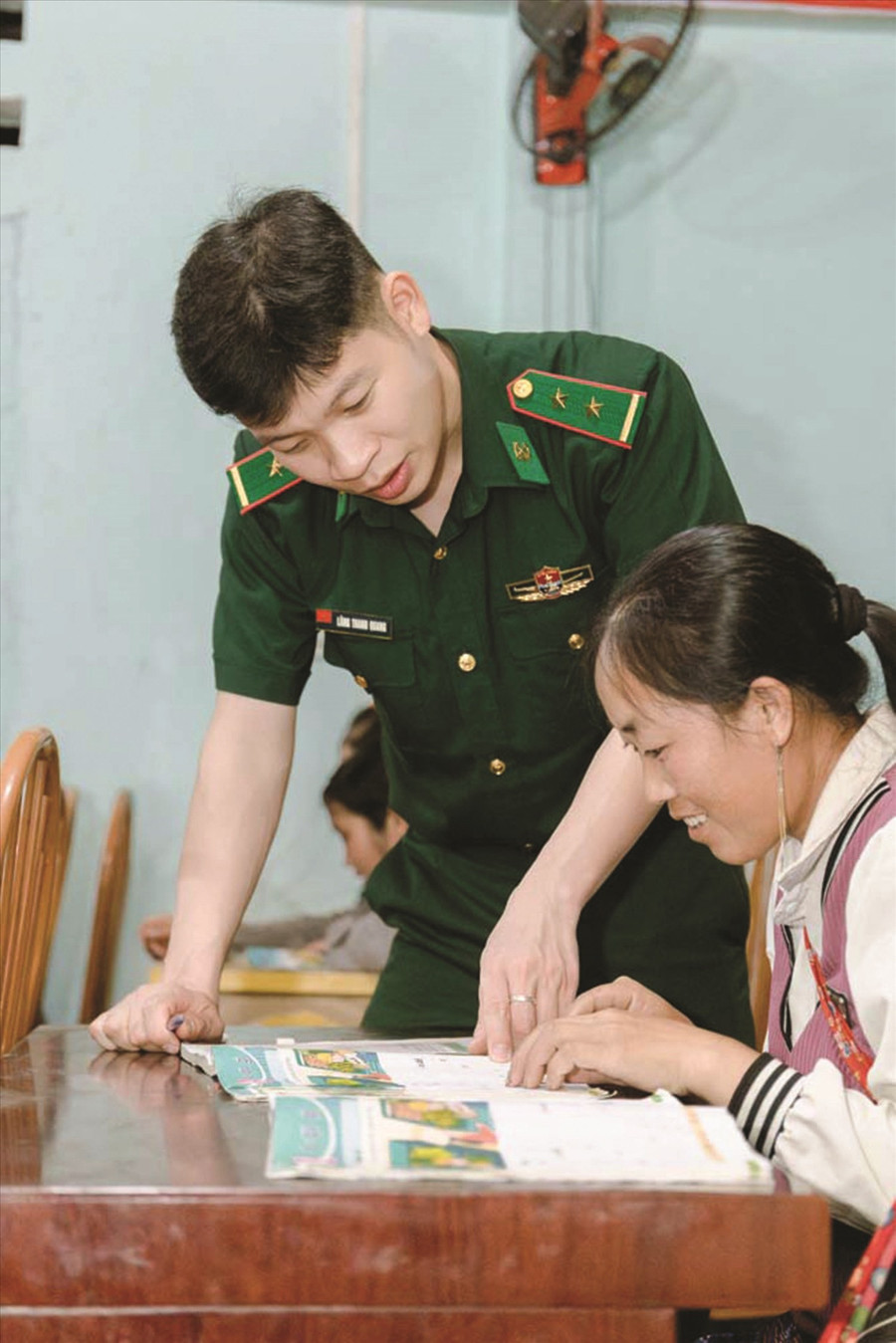 Trung úy Lăng Thanh Quang hướng dẫn học viên tập đọc. (Ảnh: Vũ Mừng) 1000046203.jpg