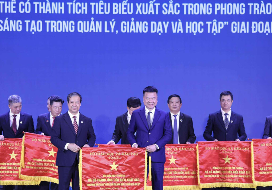 Nhà báo Triệu Ngọc Lâm - Tổng Biên tập Báo Giáo dục và Thời đại thay mặt tập thể Báo nhận Cờ thi đua từ Bộ trưởng Nguyễn Kim Sơn. Ảnh: Lê Cường. co-thi-dua.jpg