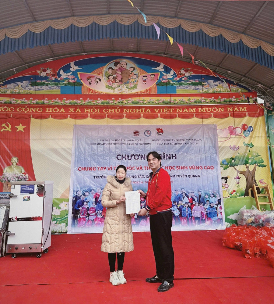 Tiến sĩ Vũ Tuấn Anh - Trưởng khoa Khoa học Thể dục Thể thao, Trường ĐHSP Hà Nội 2 trao quà thiện nguyện tới đại diện Trường Mầm non Lũng Táo, xã Lũng Cú, tỉnh Tuyên Quang. 2.jpg