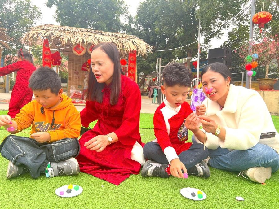 Bà Cao Thị Thanh Lý - Hiệu trưởng Trường Mầm non Cao Xá 1 (áo dài đỏ) cùng phụ huynh hướng dẫn trẻ nặn tò he. mn-cao-xa-1.jpg