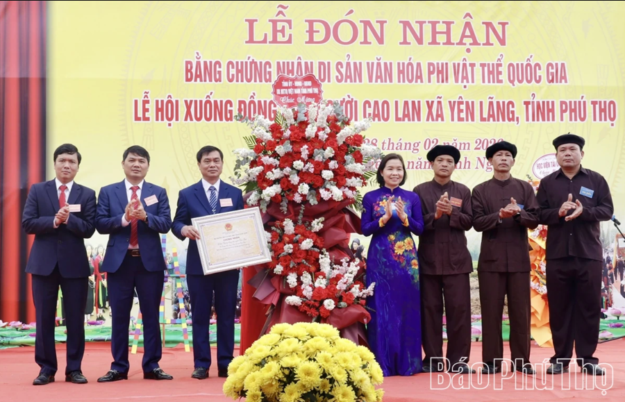 Bà Phùng Thị Kim Nga - Phó Chủ tịch UBND tỉnh Phú Thọ trao Chứng nhận Di sản văn hóa phi vật thể quốc gia Lễ hội Xuống Đồng người Cao Lan xã Yên Lãng và tặng hoa chúc mừng Đảng bộ, chính quyền và Nhân dân địa phương (ảnh Báo Phú Thọ). a.png