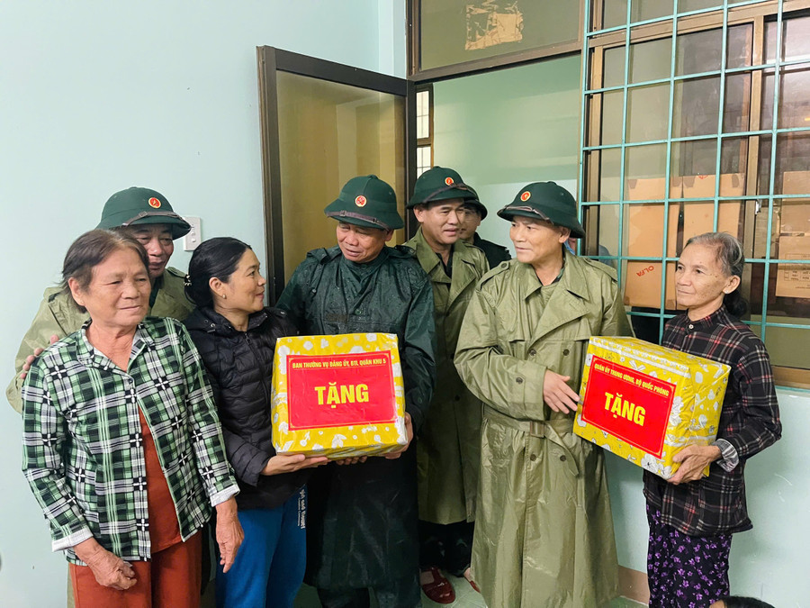 Thượng tướng Phạm Trường Sơn (thứ 2, từ phải qua) và đại diện Quân khu 5 tặng quà cho người dân đang trú bão số 13. 582826240966367646.jpg