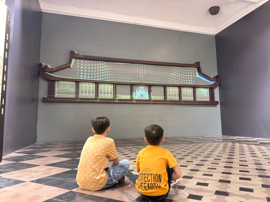 Bạn nhỏ ngồi xem ứng dụng trình chiếu 3D, tái hiện tinh hoa đất Việt. Hinh 2.jpg