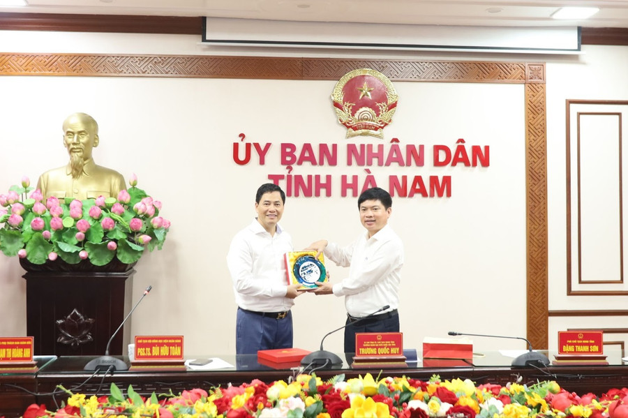 PGS.TS Bùi Hữu Toàn (trái) - Chủ tịch Hội đồng Học viện Ngân hàng tặng quà lưu niệm cho ông Trương Quốc Huy - Bí thư Tỉnh ủy, Chủ tịch UBND tỉnh Hà Nam.