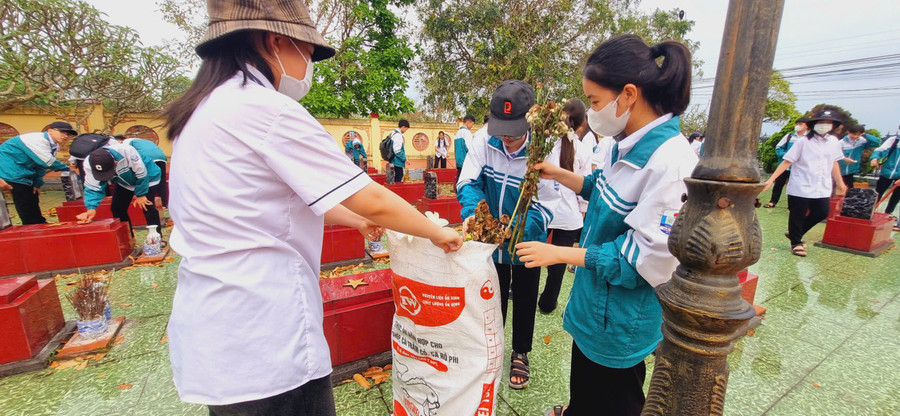 Các em thu dọn vệ sinh sạch sẽ ở Nghĩa trang liệt sĩ xã Hải Xuân. xuan-1.jpg