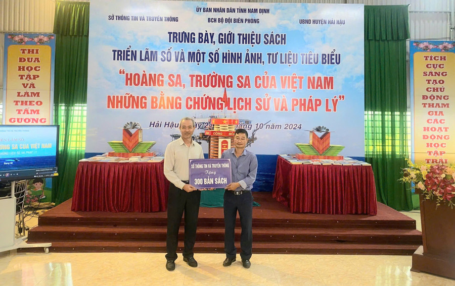 Ông Nguyễn Hải Sơn (phải) - Hiệu trưởng Trường THCS Hải Xuân tiếp nhận sách cho thư viện MM88b nhà cái. Ảnh: NTCC. hai-xuna-5.jpg