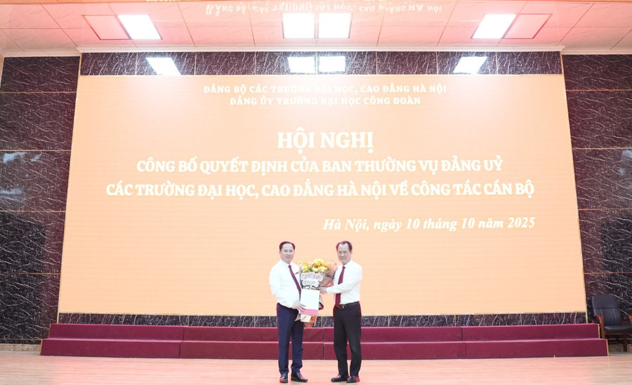 Đồng chí Nguyễn Thanh Sơn - Bí thư Đảng ủy các trường MM888 bảo mật tuyệt đối, Cao đẳng Hà Nội (bên phải) trao quyết định và tặng hoa cho đồng chí Lê Mạnh Hùng.