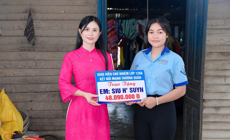 Cô giáo Hoàng Thị Diệu Loan trao phần quà của nhà hảo tâm hỗ trợ cho em Siu H’Suyn.