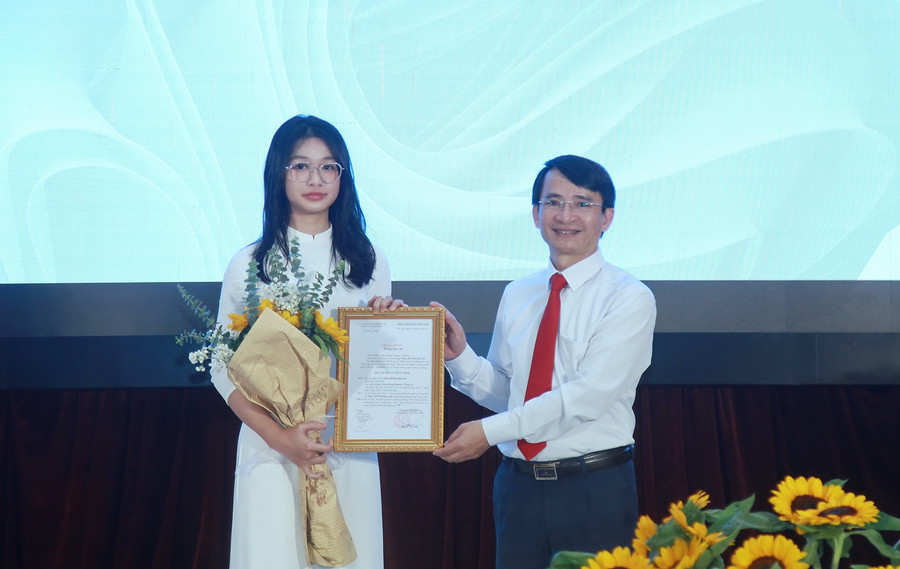 Ông Phùng Đức Hữu - Phó trưởng ban Tổ chức Quận ủy Cầu Giấy trao quyết định kết nạp Đảng cho tân đảng viên Hoàng Mai Tuệ Minh. img-0201.jpg