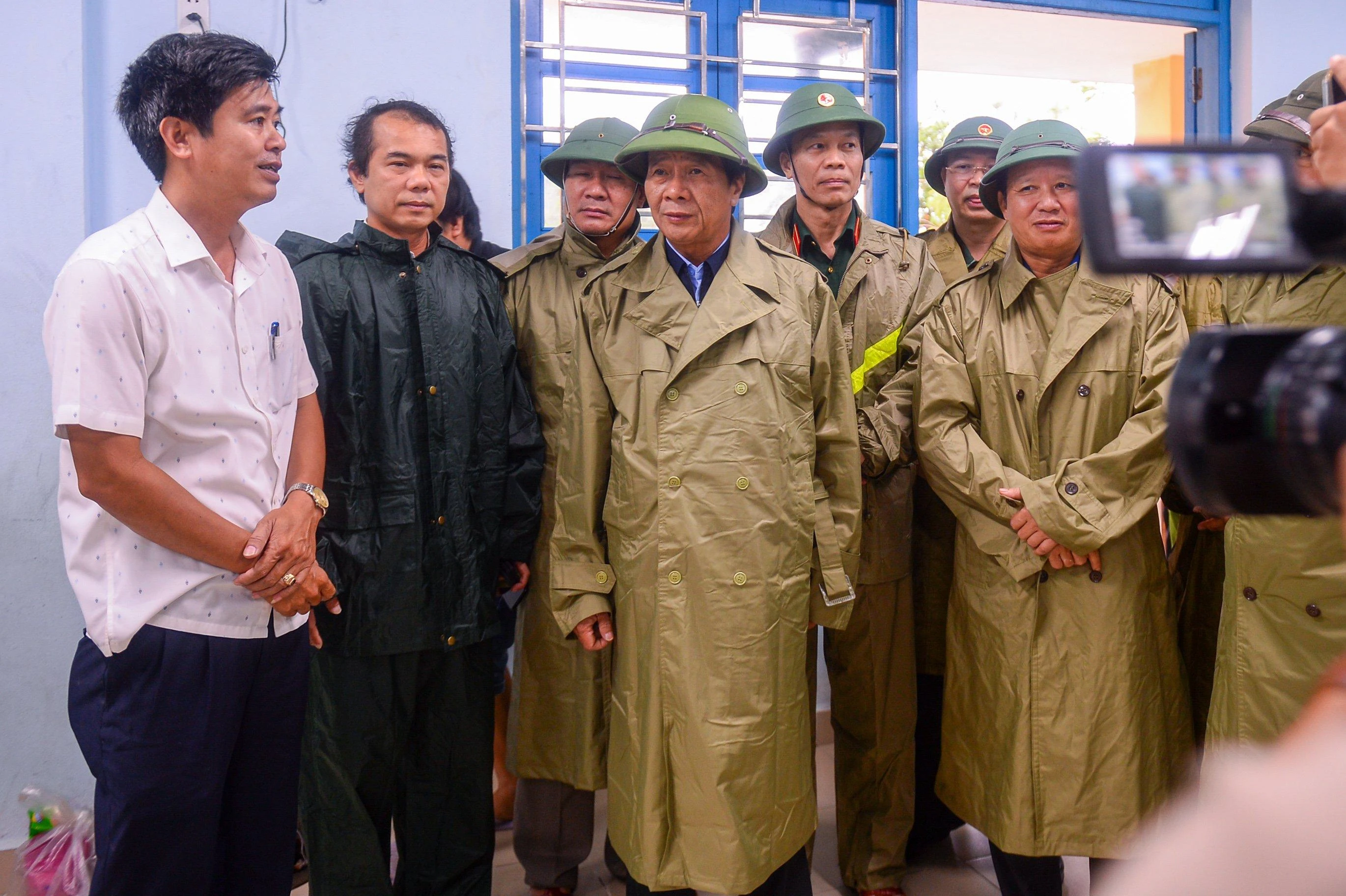 Đại diện lãnh đạo địa phương và trường học báo cáo với Phó Thủ tướng về tình hình tránh bão.