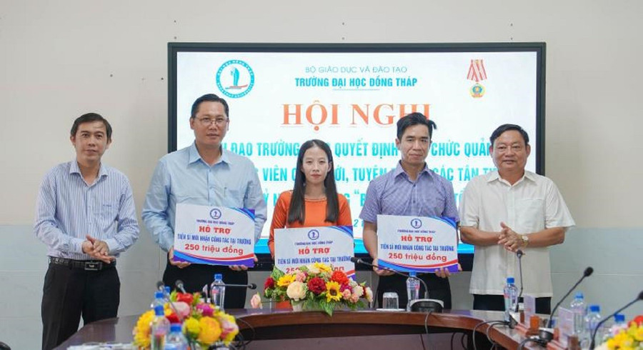 TS Trương Tấn Đạt, Chủ tịch Hội đồng trường (trái) và PGS.TS Hồ Văn Thống, Hiệu trưởng trao hỗ trợ viên chức tuyển dụng mới có học vị Tiến sĩ.