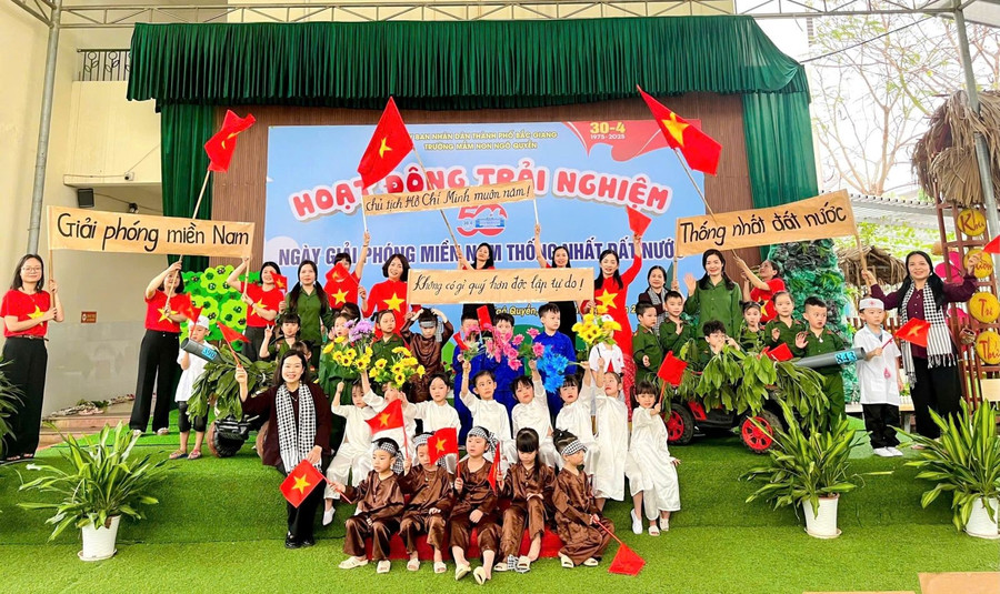 Cô trò mầm non với cờ hoa mừng kỷ niệm 50 năm Ngày Giải phóng miền Nam, thống nhất đất nước. q-1.jpg