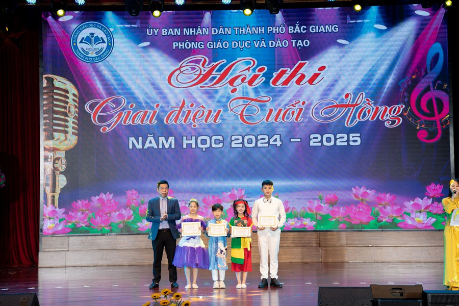 Ông Giáp Văn Tuấn - Phó Trưởng phòng GDTH-CTTT, Sở GD&ĐT Bắc Giang trao giải thưởng cho tiết mục đạt giải B của Hội thi. giai-b-hs.jpg