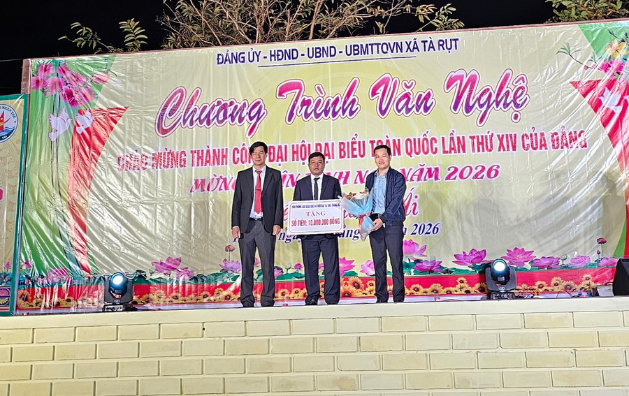 Phóng viên Báo GD&TĐ trao biển tượng trưng cho lãnh đạo xã Tà Rụt. 1000019711.jpg