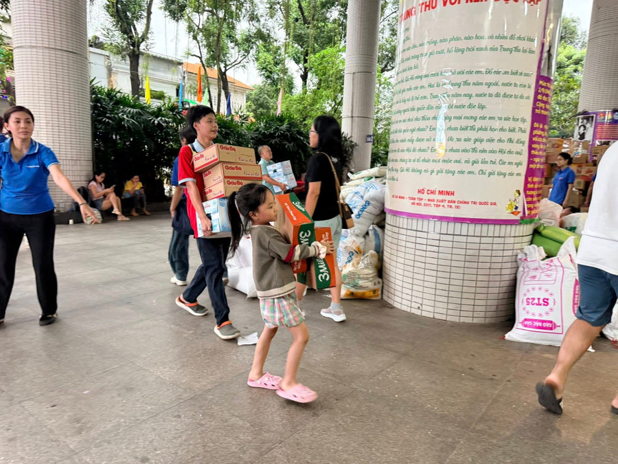 Thiếu nhi được cha mẹ đưa đến Nhà Thiếu nhi TPHCM để ủng hộ vật phẩm và góp sức cùng mọi người. Ảnh: NTNTP