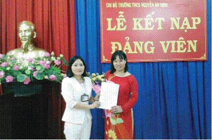 Cô Nguyễn Thị Kim Chi (áo trắng) - Hiệu trưởng Trường THCS Nguyễn An Ninh trao quyết định kết nạp đảng cho Trung Tâm Đăng Nhập MM88 Chính Thức Mới