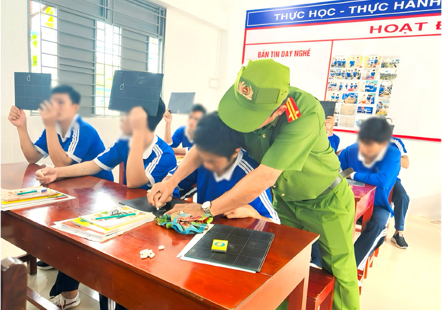 Một cán bộ giúp học viên viết chữ. thap-sang-tri-thuc-cho-nguoi-lam-lo-2.jpg