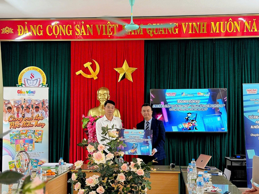 Ông Lê Như Long - Giám đốc chi nhánh Cầu Vồng tuổi thơ - Công ty CP Truyền thông và Giáo dục Cầu Vồng trao tặng Khoá Kỹ năng số “Người Hùng DQ” cho Trường Tiểu học Hồi Ninh. picture4.jpg