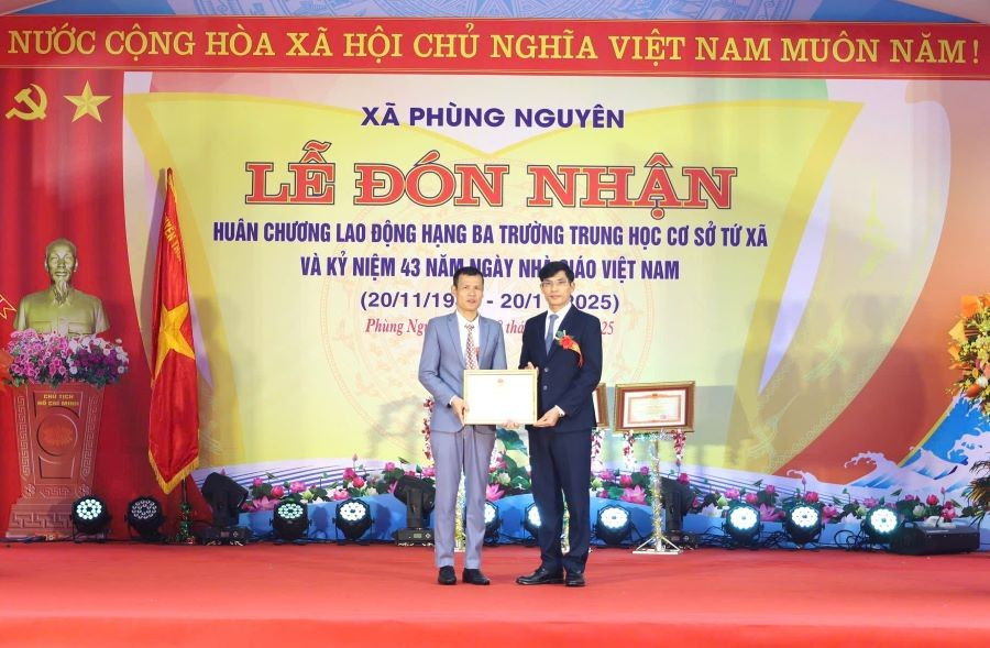 Ông Cao Văn Thắng - Bí thư Đảng uỷ, Chủ tịch HĐND xã Phùng Nguyên (bên phải) trao Bằng khen của Thủ tướng Chính phủ cho ông Nguyễn Ngọc Cầu - Hiệu trưởng Trường THCS Tứ Xã. 3.jpg