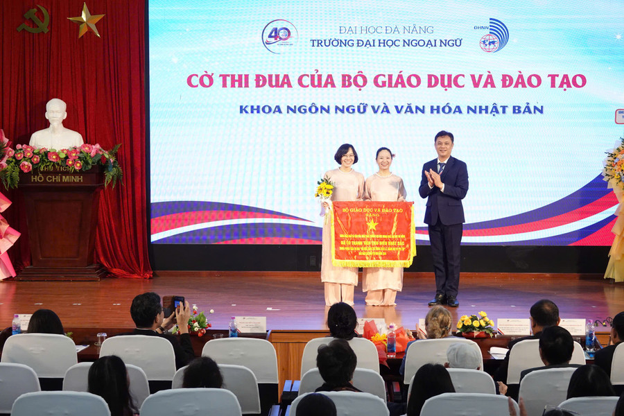 PGS.TS Nguyễn Văn Long thừa ủy quyền trao Cờ thi đua của Bộ GD&ĐT cho khoa Ngôn ngữ và Văn hóa Nhật Bản. dai-hoc-ngoai-ngu-da-nang-co-thi-dua.jpg