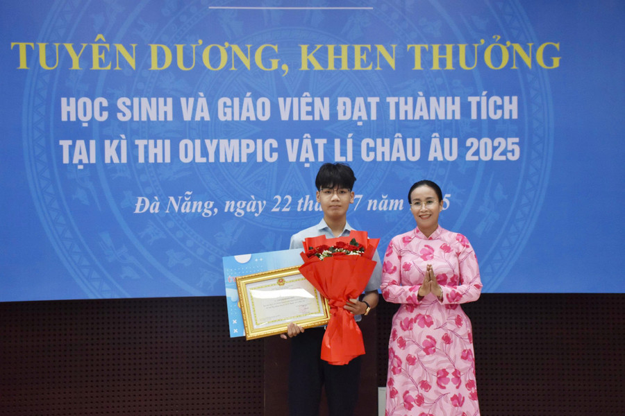 Bà Nguyễn Thị Anh Thi - Phó Chủ tịch UBND TP Đà Nẵng (bên phải) tặng hoa và trao Bằng khen cho em Cáp Kim Hoàng Bảo. da-nang-tuyen-duong-hs-gioi-quoc-te.jpg