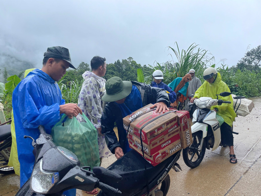 Lực lượng tình nguyện vận chuyển nhu yếu phẩm tiếp tế cho người dân đang tránh trú tại điểm trường Lăng Lương. Ảnh: Trà Thu. 