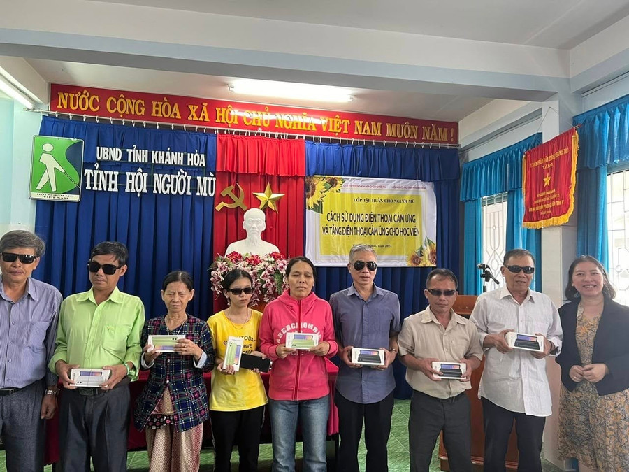Hội người mù Khánh Hòa cùng các đơn vị tài trợ trao tặng điện thoại cảm ứng cho hội viên. Ảnh: NVCC.